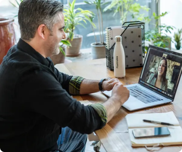 section6-image-04-webp An image of a man in front of a laptop and on a video call with a woman.