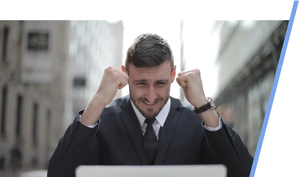 increased-profitability-webp An image of a male realtor in front of a laptop showing excitement and happiness.