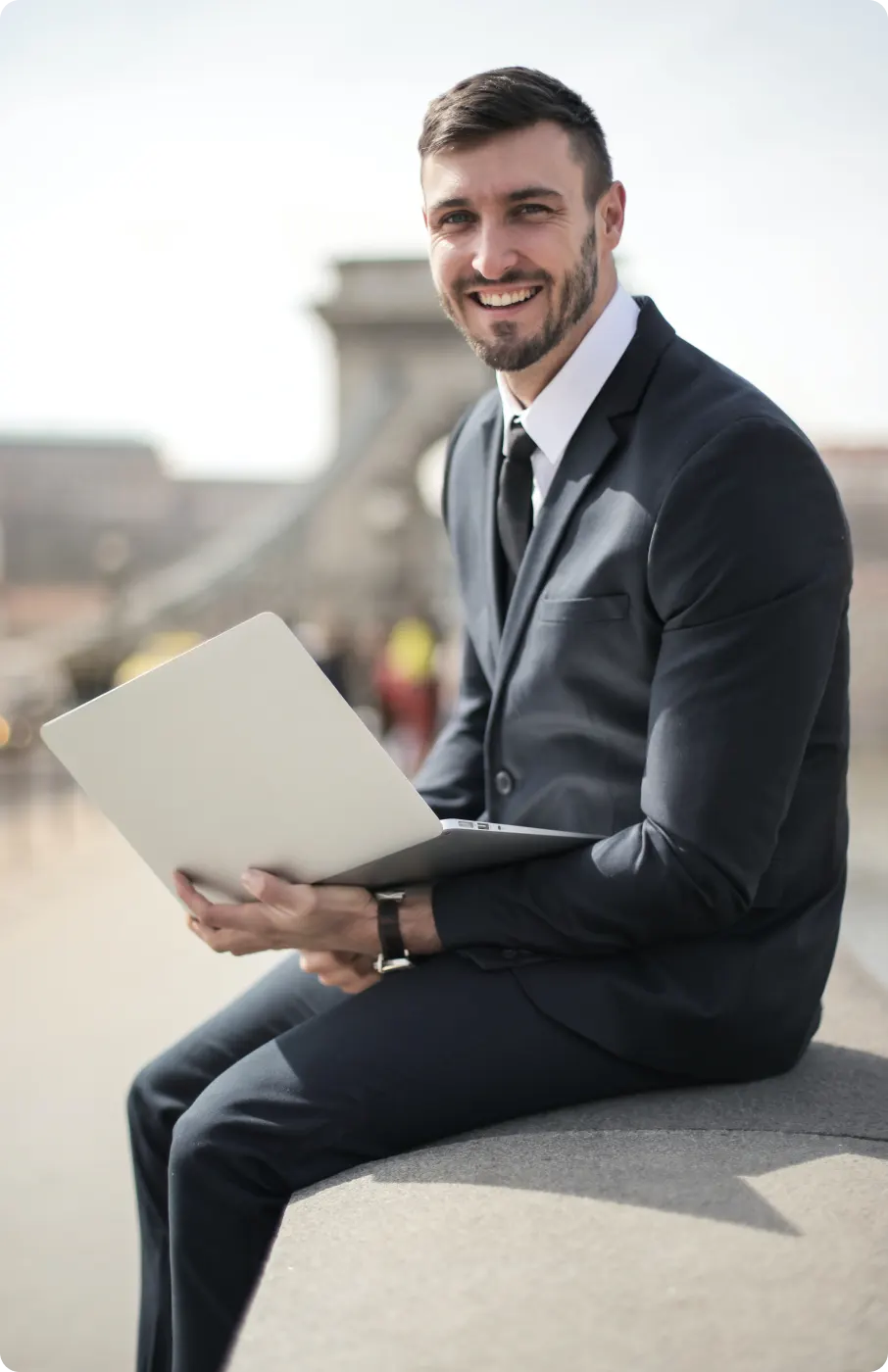 section2-image-webp An image of an smiling professional man sitting with a laptop.